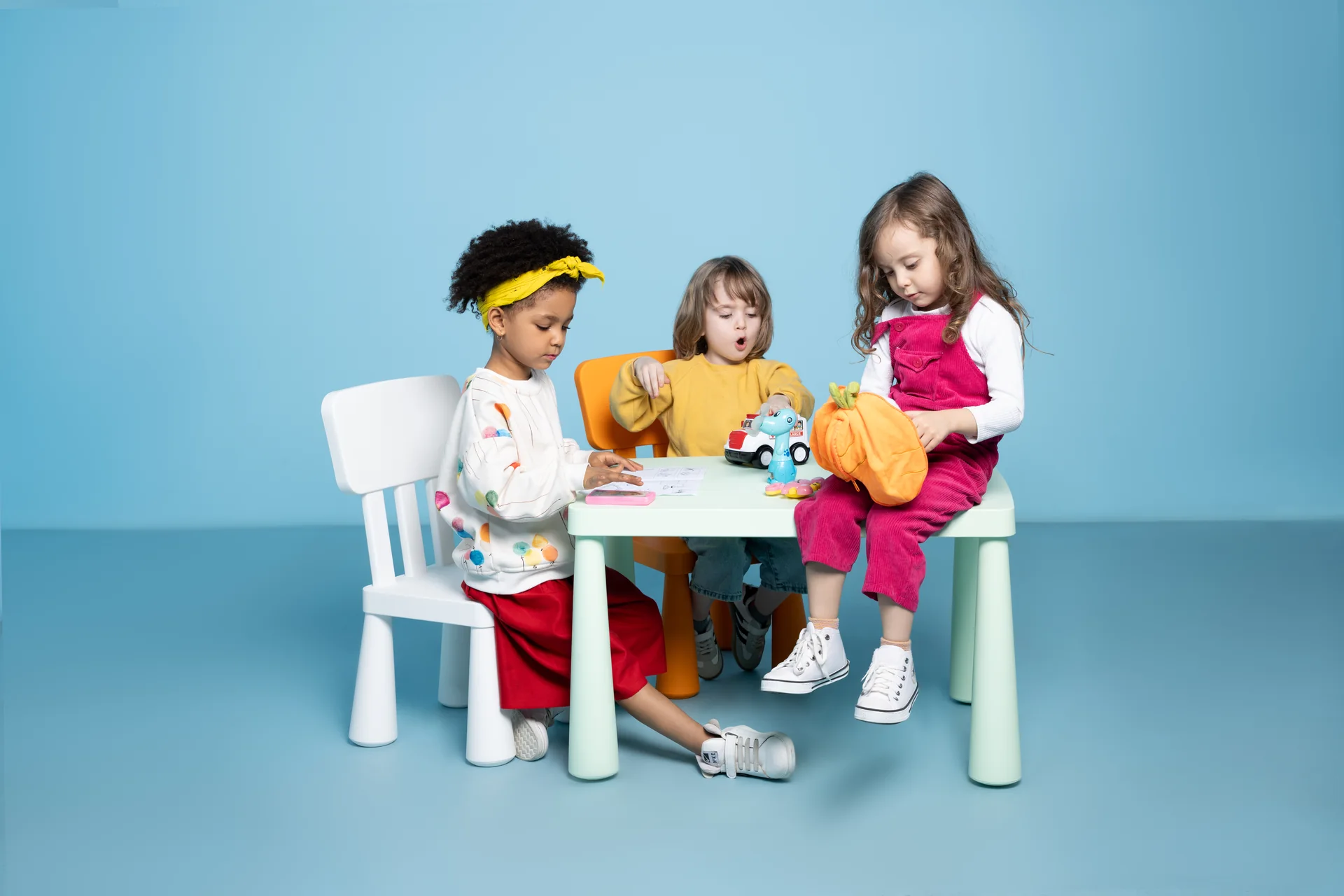 Children playing around a Chubby table with colorful Chubby chairs
